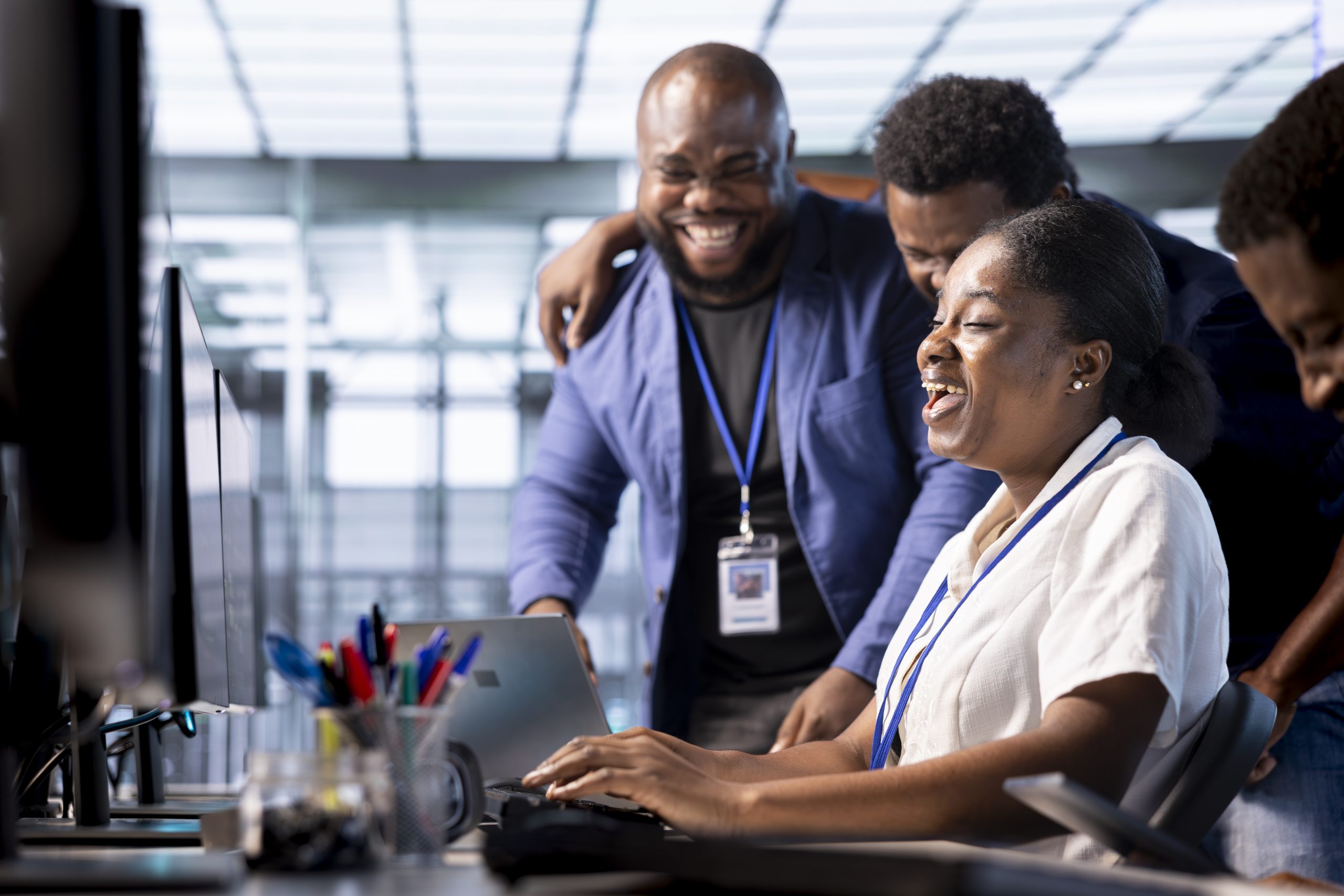 Team of happy engineers laughing, enjoying each other company while working in server farm workplace. Jolly coworkers having fun together during job break in data center office